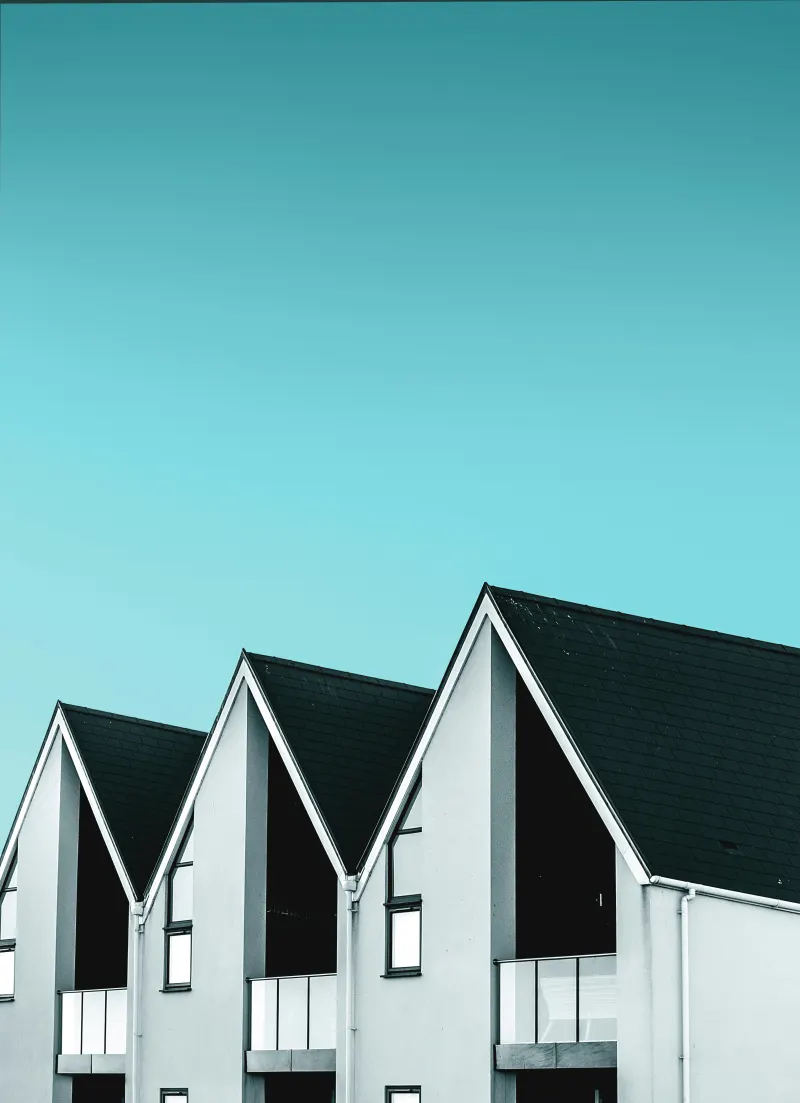 Rij moderne woningen met puntgevels tegen een blauwe lucht